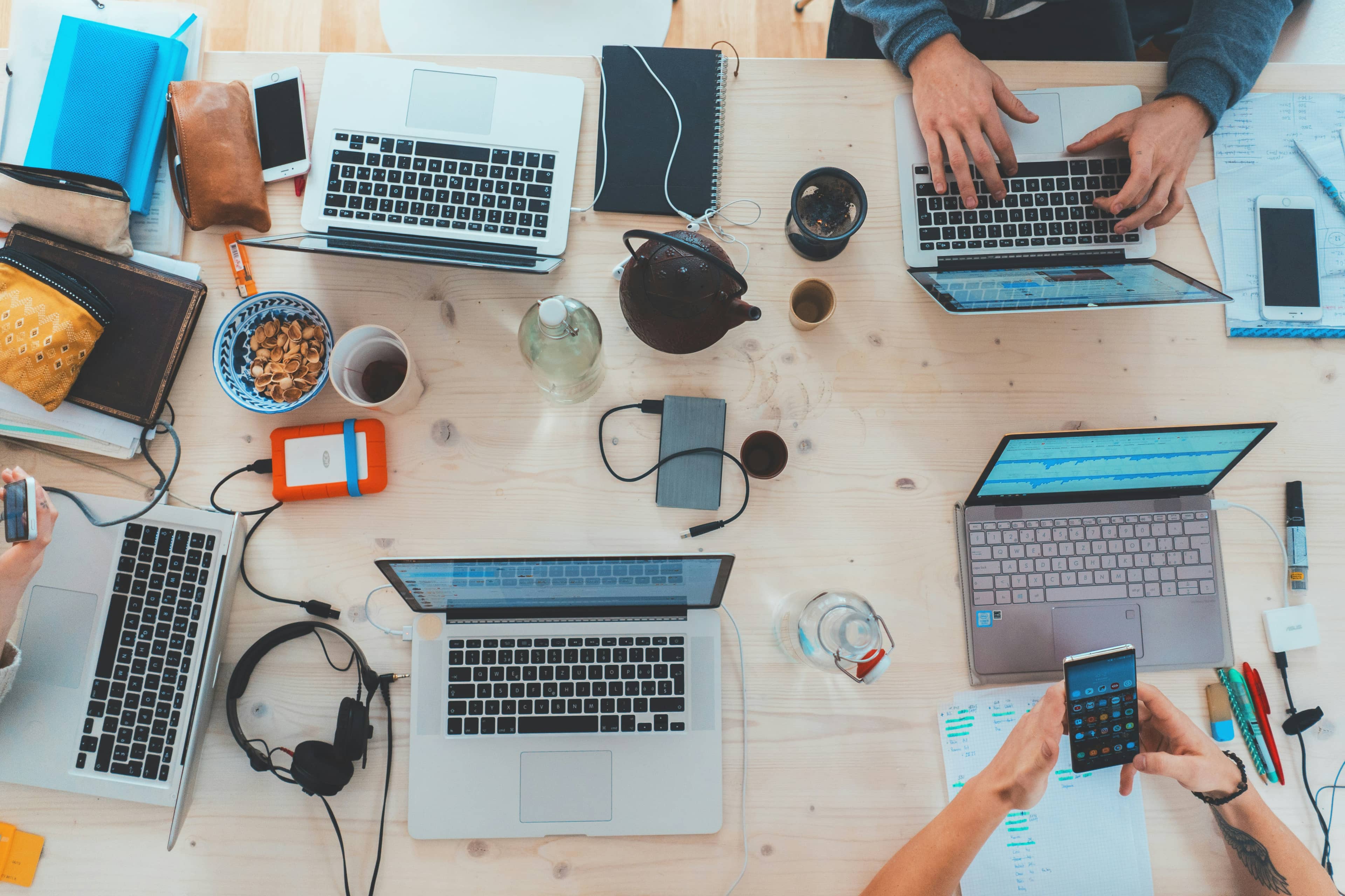 Table de bureau vue du dessus, avec des personnes travailant